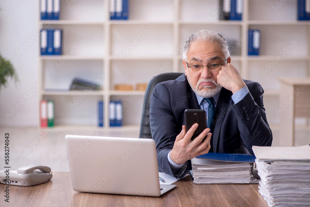 Old male employee working in the office Old male employee working in the office