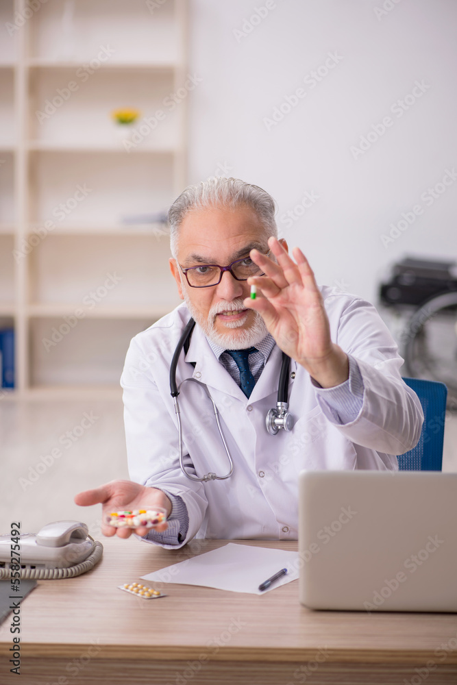 Old male doctor working in the clinic Old male doctor working in the clinic