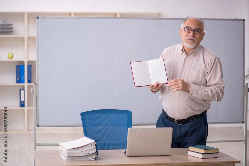 Old male teacher in front of whiteboard Old male teacher in front of whiteboard