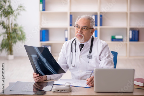 Old male doctor radiologist working in the clinic