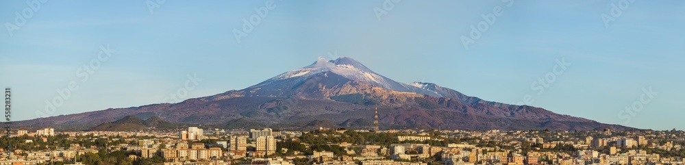 Snow covered Mount Etna volcano and Catania city center at sunrise, from vantage point in Sicily, Italy