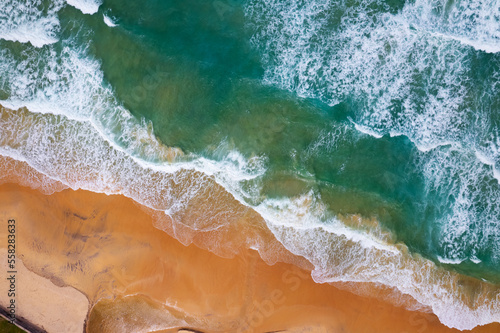 Aerial view of beach sea and waves crashing on sand beach in summer season  Amazing sea beach with ocean wave foams Beautiful top view of beautiful sea surface  Concept holiday summer background
