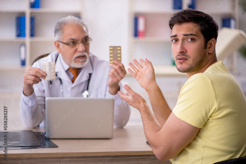 Young male patient visiting old male doctor Young male patient visiting old male doctor