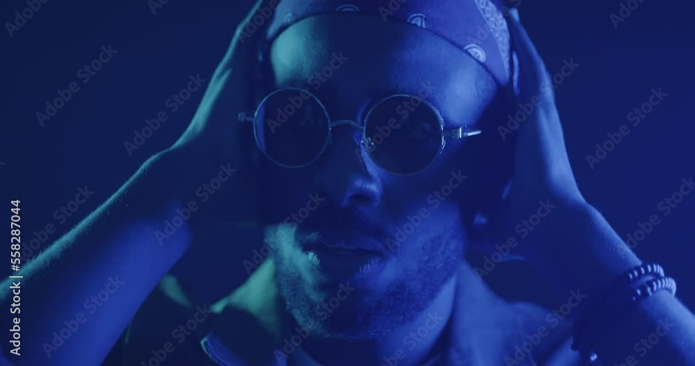 Close-up of criminals face looking at camera illuminated with red and blue police lights after accident. People and negative emotion concept. Close-up of criminals face looking at camera illuminated with red and blue police lights after accident. People and negative emotion concept.