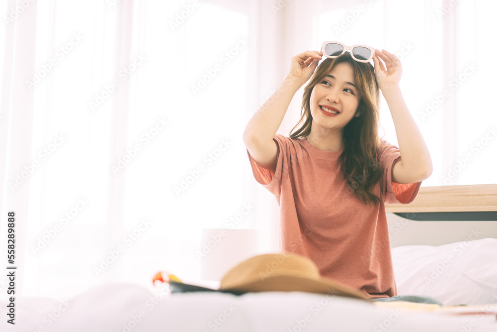 Portrait of young adult southeast asian dyed hair woman with travel luggage in bedroom Portrait of young adult southeast asian dyed hair woman with travel luggage in bedroom