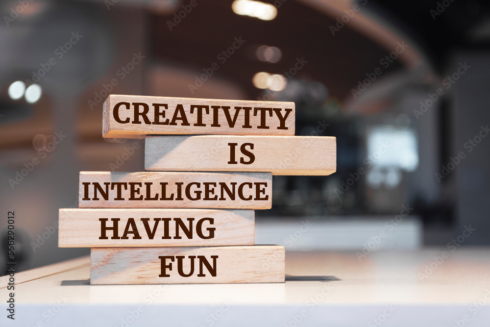 Wooden blocks with words 'Creativity Is Intelligence Having Fun'.