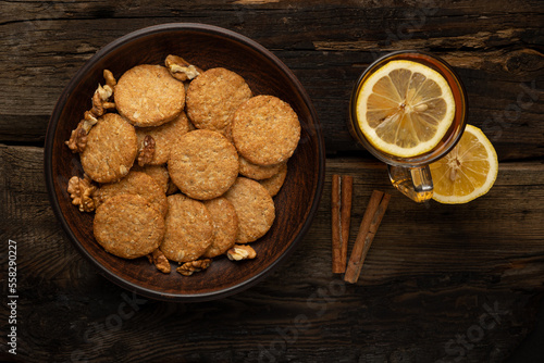 Baked crackers and tea with lemon on a wooden table.