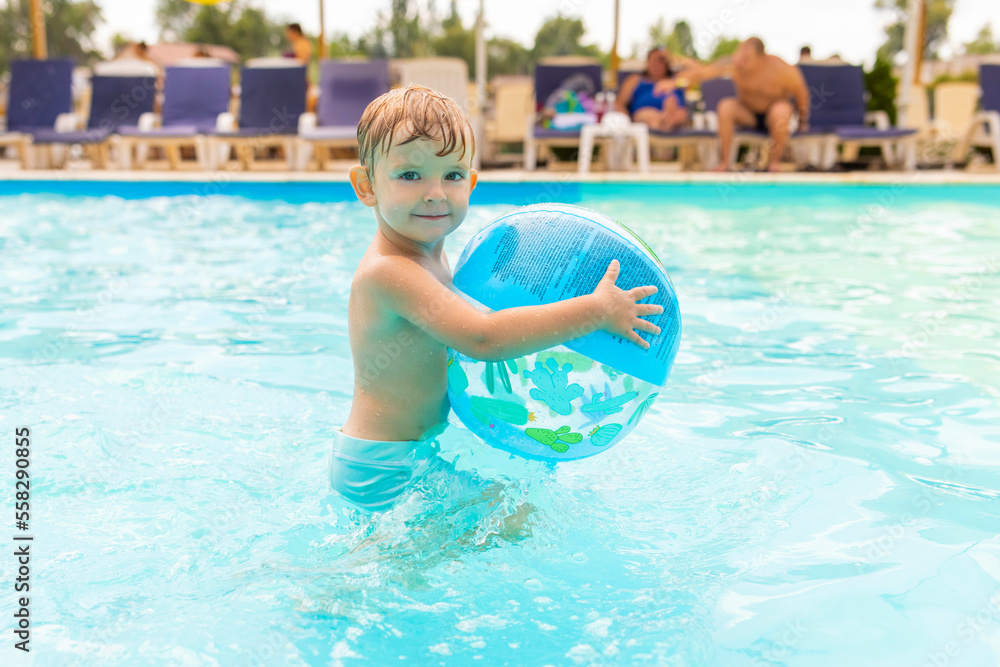 Kid swim, dive, leisure and playing inflatable ball in pool at vacation