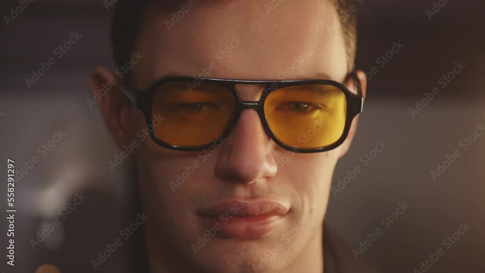A Portrait Of A Cool Guy With Yellow Eyeglasses Smile And Blink His Eyes In Front Of Camera. Close Up A Portrait Of A Cool Guy With Yellow Eyeglasses Smile And Blink His Eyes In Front Of Camera. Close Up