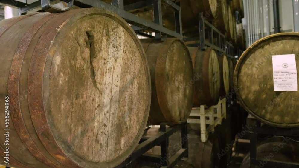 Medium wide shot tilting down of bourbon barrels fermenting inside a distillery. Medium wide shot tilting down of bourbon barrels fermenting inside a distillery.
