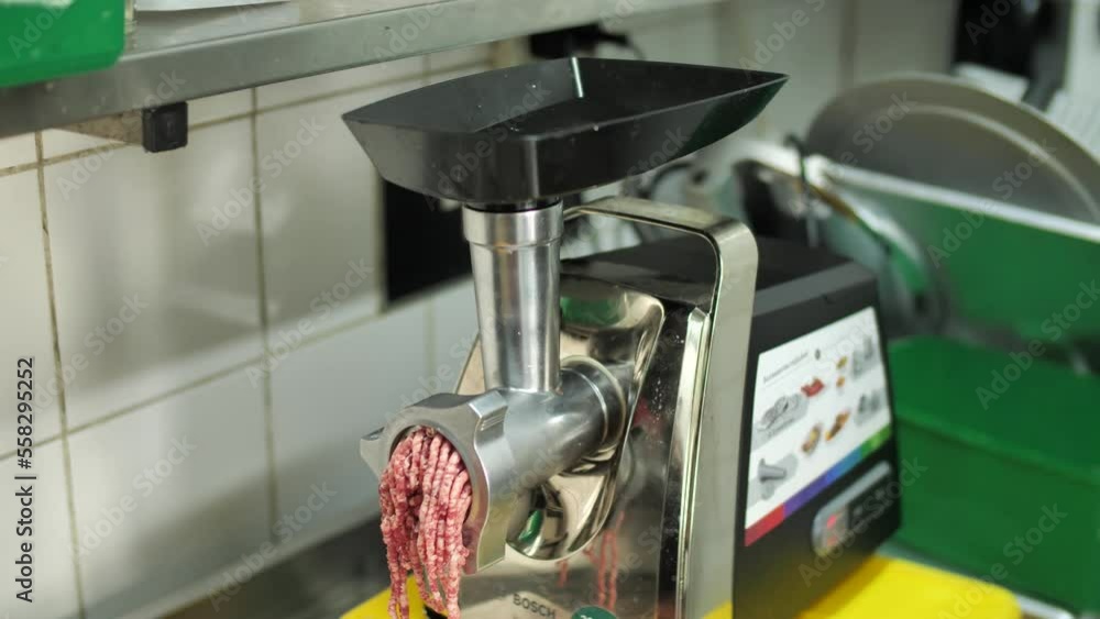 Grinding machine making minced meat in restaurant kitchen, close up Grinding machine making minced meat in restaurant kitchen, close up