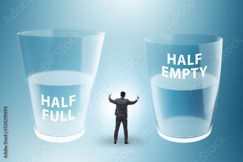 Businessman in half empty half full glass concept