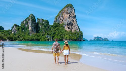 Railay Beach Krabi Thailand, the tropical beach of Railay Krabi, a couple of men and women on the beach, Panoramic view of idyllic Railay Beach in Thailand with a traditional long boat. photo