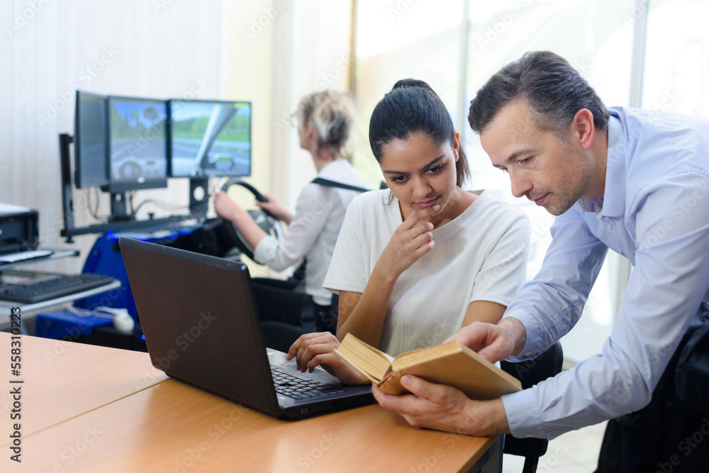male driver instructor talking to young woman in classroom male driver instructor talking to young woman in classroom