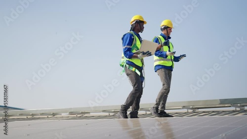 Engineer on rooftop walking next to solar panels photo voltaic check alignment for good installation