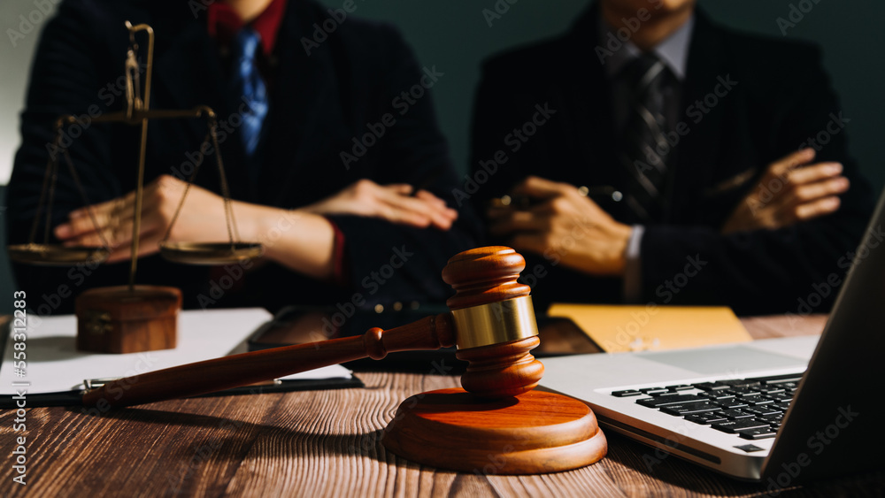 Business and lawyers discussing contract papers with brass scale on desk in office. Law, legal services, advice, justice and law concept picture with film grain effect Business and lawyers discussing contract papers with brass scale on desk in office. Law, legal services, advice, justice and law concept picture with film grain effect