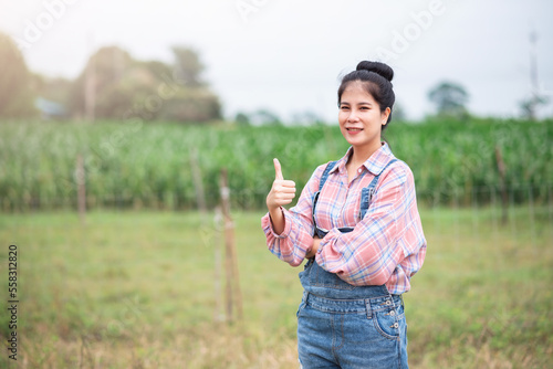 Portrait of attractive asian woman standing and showing thumb up with confident, New generation agricultural smart farmer working in dairy farm, Livestock and farm industry lifestyle.