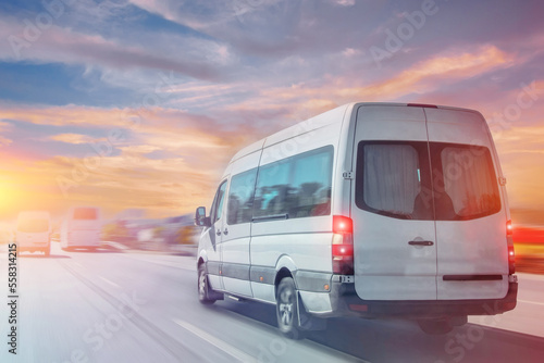 Passenger white minibus accelerating ride motion blur effect, in the morning at dawn. photo