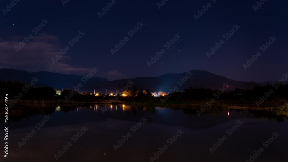 Night timelapse of distant mountains in Hod, Chiang Mai, Thailand with moon setting, moving clouds and stars Night timelapse of distant mountains in Hod, Chiang Mai, Thailand with moon setting, moving clouds and stars