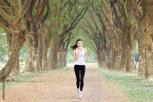 Healthy young woman running in the park at morning