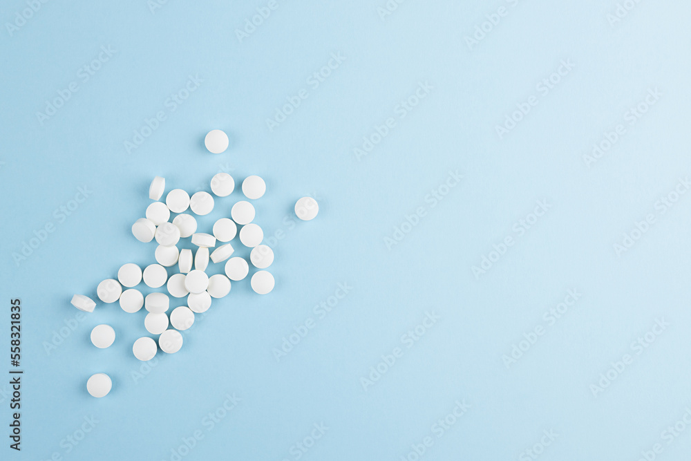 Heap of white tablets pattern on soft light blue color, top view, copy space. Medical, pharmacy remedies for health and prevent, teraphy disease background in modern style - home medicine chest. Heap of white tablets pattern on soft light blue color, top view, copy space. Medical, pharmacy remedies for health and prevent, teraphy disease background in modern style - home medicine chest.