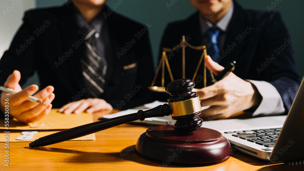Business and lawyers discussing contract papers with brass scale on desk in office. Law, legal services, advice, justice and law concept picture with film grain effect Business and lawyers discussing contract papers with brass scale on desk in office. Law, legal services, advice, justice and law concept picture with film grain effect