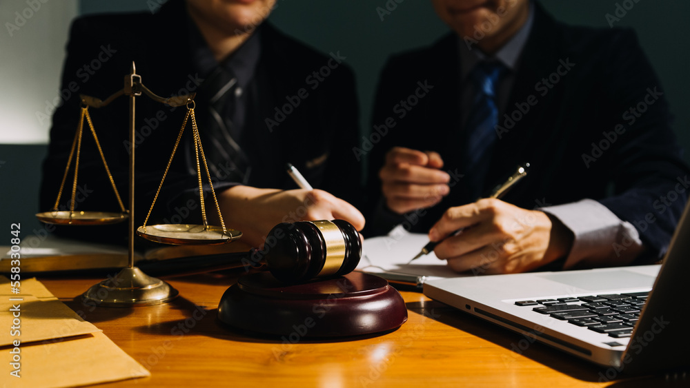 Business and lawyers discussing contract papers with brass scale on desk in office. Law, legal services, advice, justice and law concept picture with film grain effect Business and lawyers discussing contract papers with brass scale on desk in office. Law, legal services, advice, justice and law concept picture with film grain effect