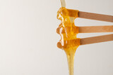 Liquid yellow sugar paste or wax for epilation on three wooden sticks or spatulas closeup