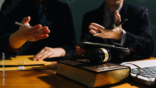 Business and lawyers discussing contract papers with brass scale on desk in office. Law, legal services, advice, justice and law concept picture with film grain effect