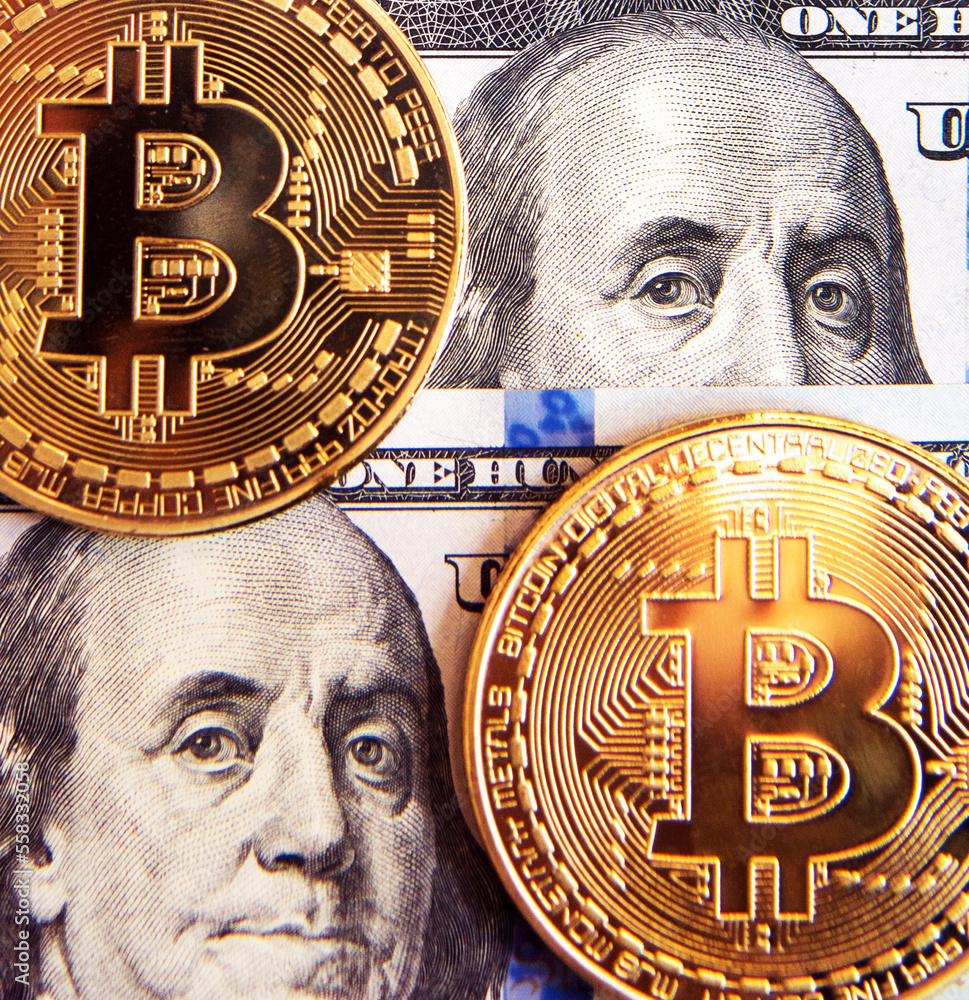 One hundred dollar bill and bitcoin coins as a symbol of the strength of paper money against the background of falling digital currency. (Investment, course change - concept)