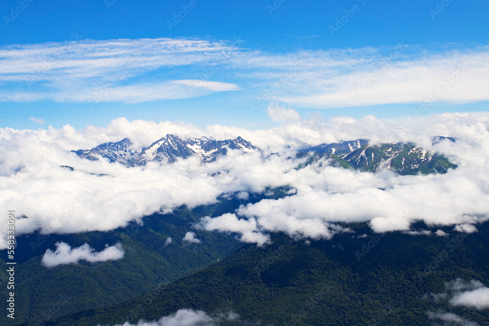 mountain landscape with blue sky above clouds, hilltops and natural green forests, background and wallpaper