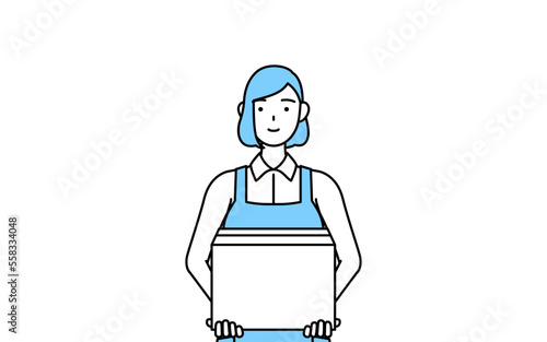 段ボールを運ぶ作業をするエプロンを着た女性