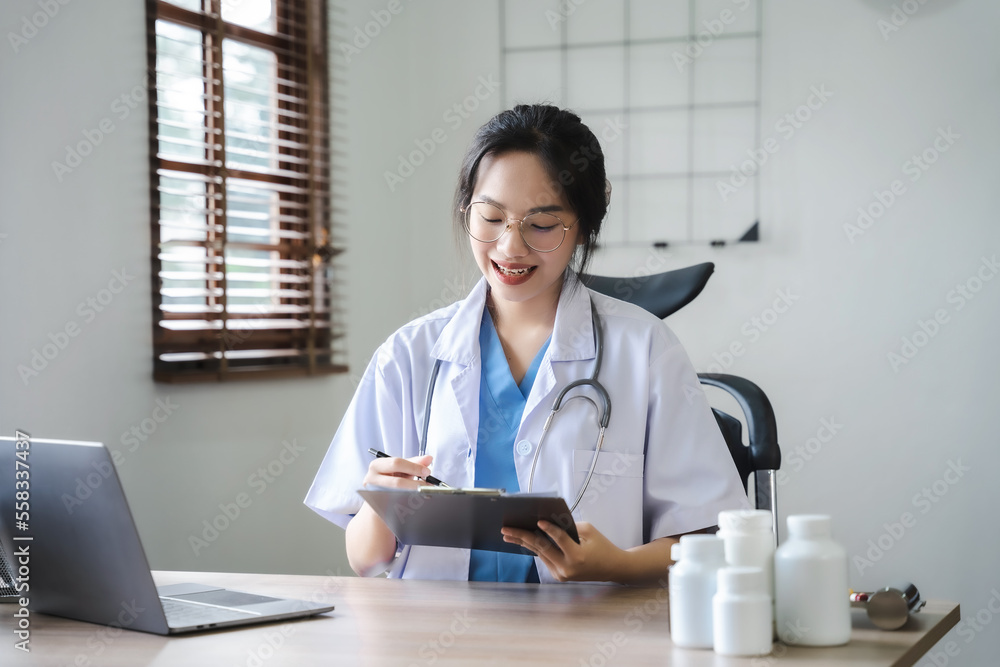 Doctor women working on laptop computer, writing prescription clipboard with record information paper folders on desk in clinic, Healthcare and medical concept. Doctor women working on laptop computer, writing prescription clipboard with record information paper folders on desk in clinic, Healthcare and medical concept.