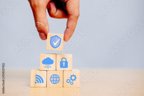 Hand holding wooden cube with icons security, Cybersecurity protection and data security concept with document icons.