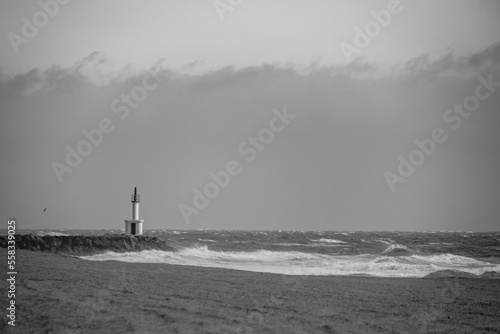Black and white photograph of a small lighthouse on the beach at Les Barcares, in France.