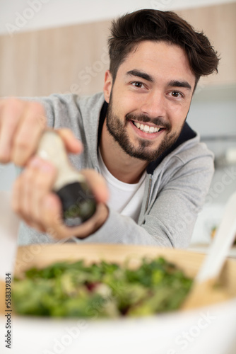 man adding salt to a lunch salad