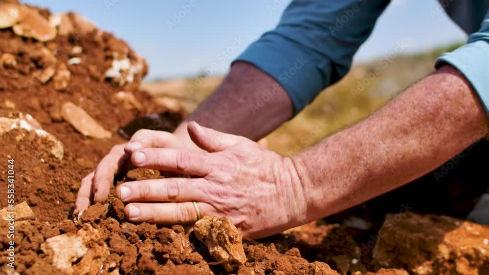 A male worker at a vineyard, kneeled down to check the quality of the soil by sampling it with his own bare hands. Handheld slow motion closeup shot.
A male worker at a vineyard, kneeled down to check the quality of the soil by sampling it with his own bare hands. Handheld slow motion closeup shot.