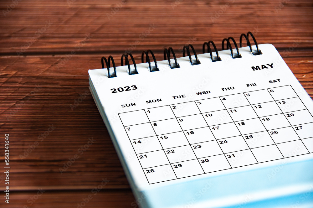 May 2023 white desk calendar on wooden table background. Calendar concept and copy space May 2023 white desk calendar on wooden table background. Calendar concept and copy space