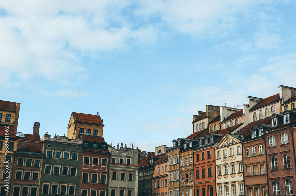 Panoramic landscape with old town colorful houses in different shapes and heights over sunny blue sky 