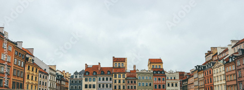 Panoramic landscape with old town colorful houses in different shapes and heights over cloudy sky 