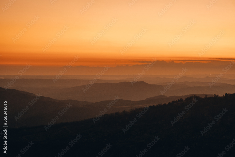Panorama of mountain valley illuminated by sunset colors