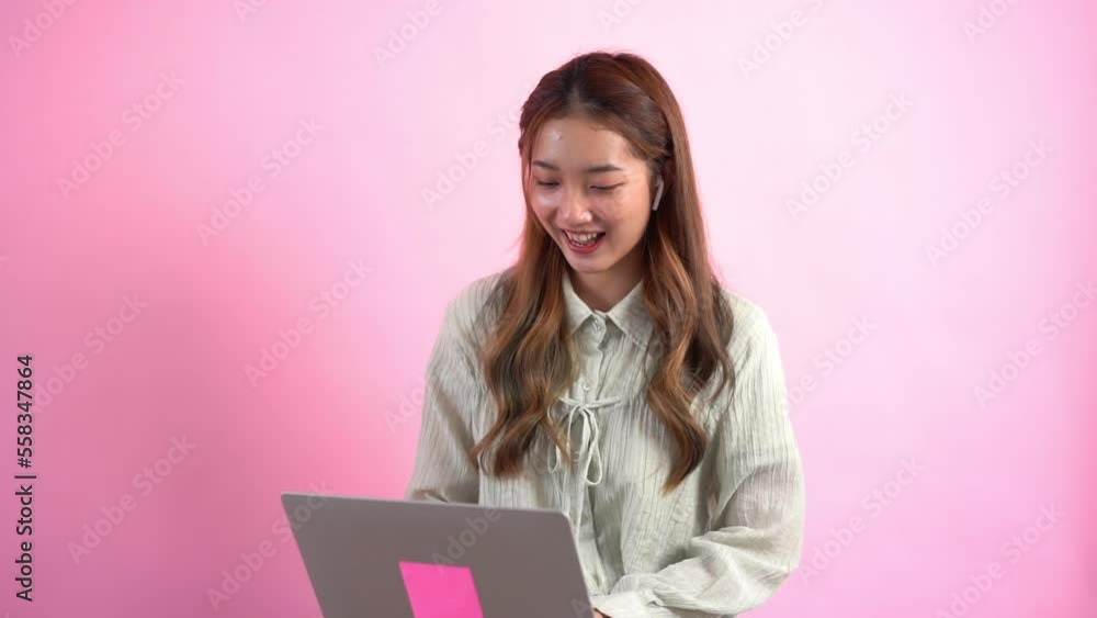 Young women working and typing to chatting with colleague on laptop isolated on pink background Young women working and typing to chatting with colleague on laptop isolated on pink background