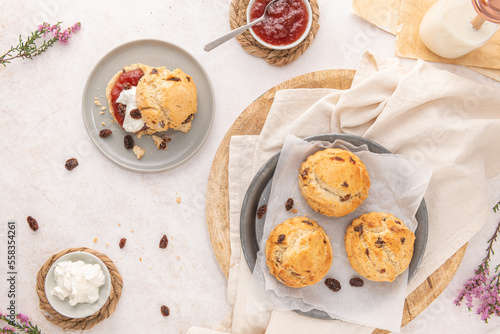 Homemade raisin scones with clotted cream and strawberry jam ready to eat