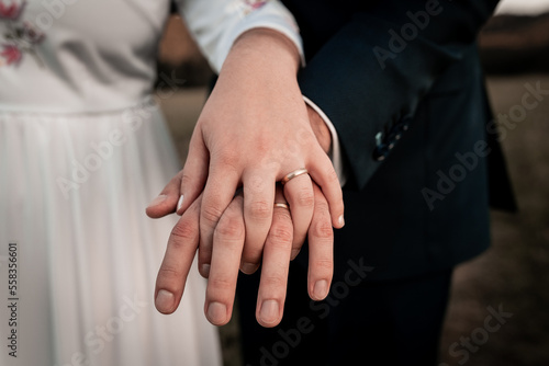 Love is in the air, young couple is holding hands, detail on rings,wedding day