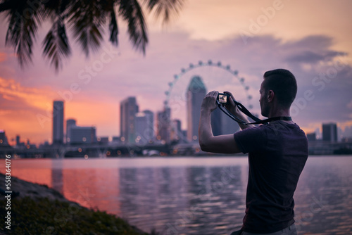 Photography Man photographing Singapore urban skyline at beautiful sunset