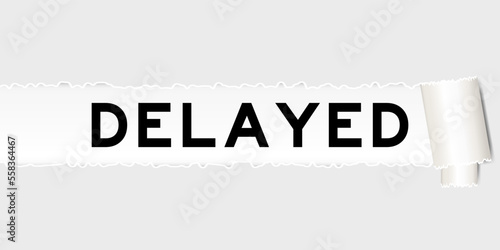 Ripped gray paper background that have word delayed under torn part