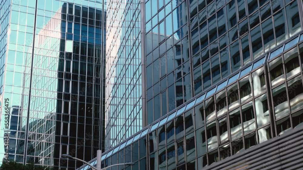 Abstract modern business architecture. Walls made of glass and steel with reflections of buildings and blue sky. Abstract modern business architecture. Walls made of glass and steel with reflections of buildings and blue sky.
