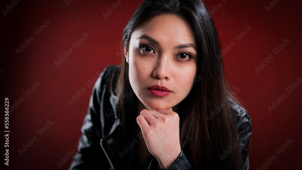Young self-confident woman against a red background - studio photography Young self-confident woman against a red background - studio photography