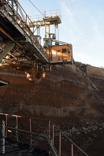 Bucket-wheel excavator during excavation at the surface mine. Huge excavator on open pit mine.