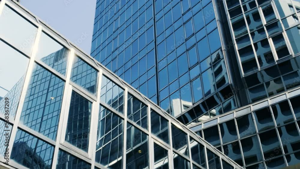 Abstract modern business architecture. Walls made of glass and steel with reflections of buildings and blue sky. Abstract modern business architecture. Walls made of glass and steel with reflections of buildings and blue sky.